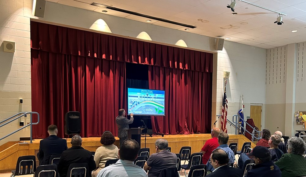 person pointing to their presentation in front of an audience