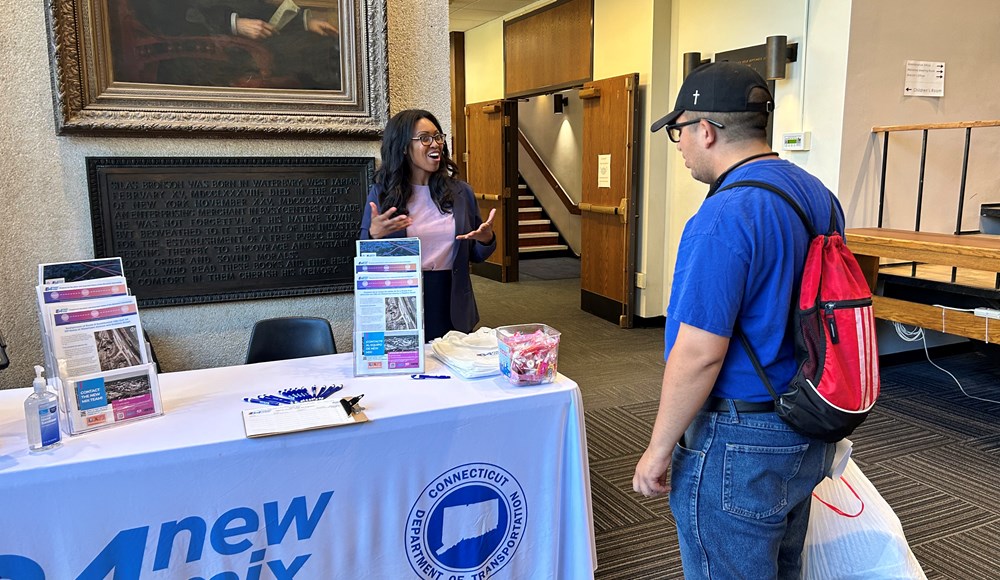 event staff behind the event table talking with attendee
