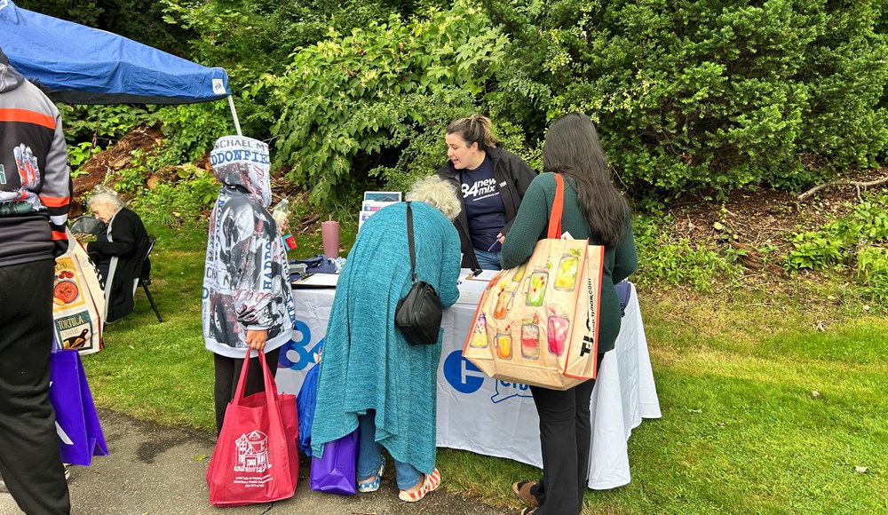 event attendees talking with staff at event table